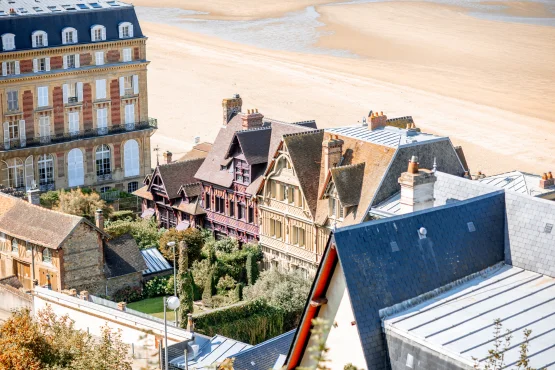 Maisons et grand bâtiment en bord de plage, vus depuis les hauteurs.